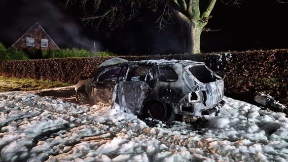 Ein Auto in Großheide ist nach einem Brand zerstört. Löschschaum ist zu sehen. © L-J Krumm Foto: L-J Krumm