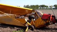 Ein Kleinflugzeug liegt nach einem Absturz auf einem Feld. © TV7 News 