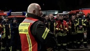 Der Kreisbrandmeister des Landkreises Leer spricht zu Feuerwehrleuten. © NonstopNews 