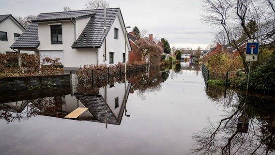 Wasser steht in einer Wohnstraße nahe der Wörpe in Lilienthal. © Focke Strangmann/dpa Foto: Focke Strangmann