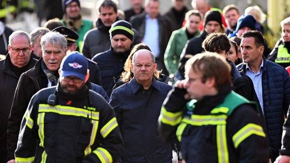Bundeskanzler Olaf Scholz inmitten von Feuerwehrleuten in Verden. © Philipp Schulze/dpa +++ dpa-Bildfunk +++ Foto: Philipp Schulze