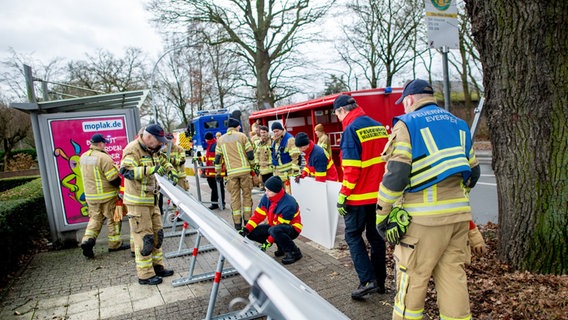 Einsatzkräfte der Feuerwehr stellen einen mobilen Deich im Stadtteil Bümmerstede auf. © Hauke-Christian Dittrich/dpa Foto: Hauke-Christian Dittrich