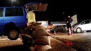 Ein Feuerwehrmann lädt in Oldenburg Sandsäcke in das Auto eines Anwohners. © TeleNewsNetwork 