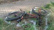 Ein Fahrrad liegt nach einem Unfall auf dem Seitenstreifen einer Straße. © Nord-West-Media TV 