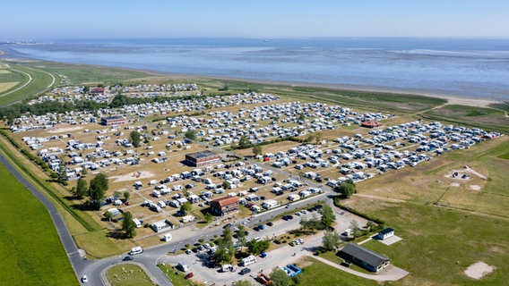 Wohnmobile und Wohnwagen stehen auf dem Campingplatz in Hooksiel hinter dem Deich (Luftaufnahme mit Drohne). © picture-alliance Foto: Hauke-Christian Dittrich