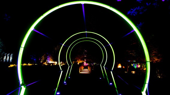 Mehrere illuminierte Torbögen bilden im Park der Gärten ein überdimensionales Schlüsselloch. © dpa-Bildfunk Foto: Hauke-Christian Dittrich