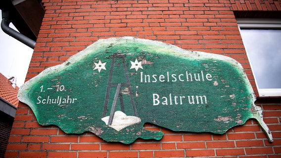 Ein Schild an einem Gebäude weist die Inselschule Baltrum aus. © dpa-Bildfunk Foto: Sina Schuldt