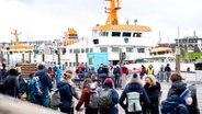 Zahlreiche Touristen warten im Fährhafen in Bensersiel vor der Überfahrt zur Insel Langeoog auf den Zugang zum Fährschiff. © picture alliance/dpa | Hauke-Christian Dittrich Foto: Hauke-Christian Dittrich