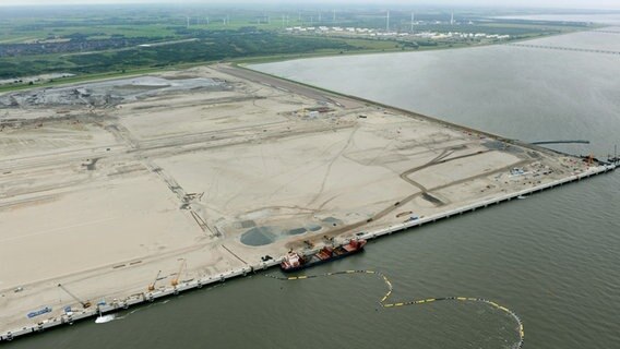 Das Hafengelände von Wilhelmshaven ist Ende Juli 2011 weitgehend aufgespült und die Kajenanlage fast vollendet. Im Hintergrund sind die Anleger des Ölterminals zu sehen. © picture alliance / dpa Foto: Ingo Wagner