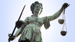 Justitia hält Schwert und Waagschale. © dpa 