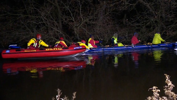 Einsatzkräfte des DLRG legen mit einem Schlauchboot an einem Kanu in einem Fluss an. © NonstopNews 
