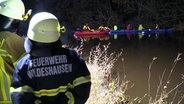 Einsatzkräfte des DLRG legen mit einem Schlauchboot an einem Kanu in einem Fluss an. © NonstopNews 