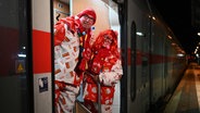 Zwei Karnevalisten aus Leer steigen am frühen Morgen verkleidet in einen Zug nach Köln. © dpa Foto: Lars Penning