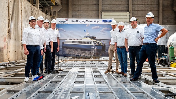 Mitarbeiter der Frisia-Reederei stehen bei der Kiellegung eines Elektro-Katamarans zusammen. © Reederei Norden-Frisia 