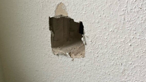 In eine Zimmerwand ist ein Loch geschlagen. © picture alliance 