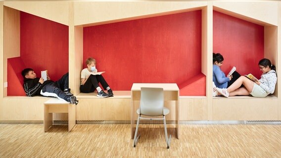 Schülerinnen und Schüler lesen auf Sitzgelegenheiten inder KGS Leeste. © Frank Schinski Foto: Frank Schinski