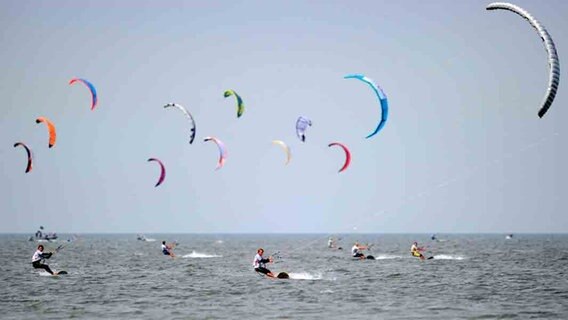 Kitesurfer starten am Strand von St. Peter-Ording in der Nordsee. © dpa Foto: Angelika Warmuth