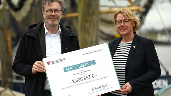 Niedersachsens Landwirtschaftsministerin Barbara Otte-Kinast (CDU) und Gerd Kraus, Leiter des Thünen-Instituts für Seefischerei, zeigen im Hafen die Förderurkunde über rund 2,3 Millionen Euro. © dpa-Bildfunk Foto: Lars Klemmer