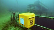 Ein gelber Briefkasten ist im Kreidesee im Hemmoor in einer Tiefe von 19 Metern unter Normalnull angebracht. © Tauchbasis Kreidesee Foto: Jens-Uwe Lamm