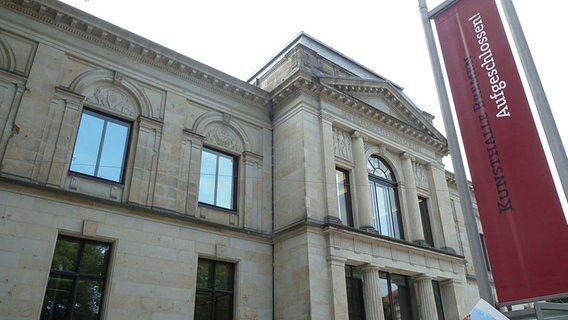 Die Vorderseite der Bremer Kunsthalle mit einer roten Fahne im Vordergrund auf der steht: "Kunsthalle Bremen Aufgeschlossen!"  Foto: Silke Rudolph