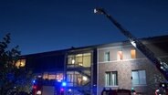 Einsatzkräfte der Feuerwehr stehen vor einem Pflegeheim in Lingen. © Nord-West-Media TV 
