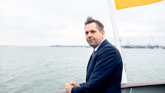 Wirtschaftsminister Olaf Lies (SPD) steht auf einem Schiff vor dem Anleger für das LNG-Terminal in der Nordsee vor Wilhelmshaven. © dpa-Bildfunk Foto: Hauke-Christian Dittrich