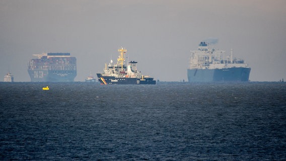 Das Spezialschiff «Höegh Esperanza» (r) erreicht den Jadebusen, während ein Schiff der Küstenwache in der Nordsee liegt. © Hauke-Christian Dittrich/dpa Foto: Hauke-Christian Dittrich