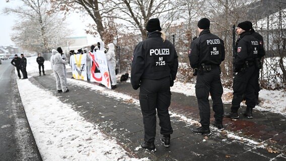 Von Polizisten beobachtet demonstrieren Menschen auf der Zufahrt zum Flüssiggas-Terminal in Wilhelmshaven. © dpa-Bildfunk Foto: Sina Schuldt