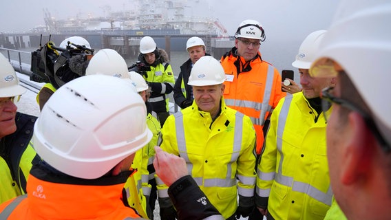 Bundeskanzler Olaf Scholz (M) nimmt an der Eröffnung des LNG-Terminals in Wilhelmshaven vor dem Spezialschiff "Höegh Esperanza" teil. © Michael Sohn/POOL AP/dpa Foto: Michael Sohn