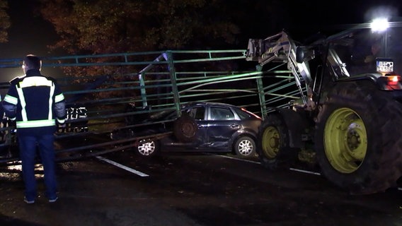 Ein Pkw steht zerstört nach einem Unfall mit einem Viehtreibewagen auf einer Landstraße. © Nord-West-Media TV 