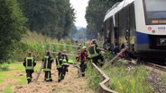Feuerwehrleute betreuen Passagiere nach einem Zugunfall in Lohne. © Nord-West-Media TV 