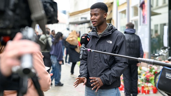 Suraj Mailitafi von der Initiative "Gerechtigkeit für Lorenz" gibt Interviews am Ort in der Oldenburger Innenstadt, an dem der 21-jährige Lorenz von der Polizei erschossen worden war. © dpa-Bildfunk Foto: Izabela Mittwollen