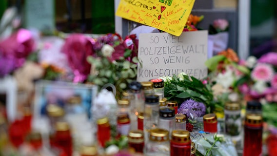 Blumen, Kerzen und ein Schild mit der Aufschrift "So viel Polizeigewalt, so wenig Konsequenzen" stehen am Ort in der Oldenburger Innenstadt, an dem der 21-jährige Lorenz von der Polizei erschossen worden war. © dpa-Bildfunk Foto: Izabela Mittwollen