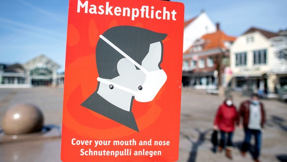 Ein Schild mit der Aufschrift "Maskenpflicht" hängt auf dem Marktplatz in der Innenstadt von Aurich. © dpa Foto: Hauke-Christian Dittrich