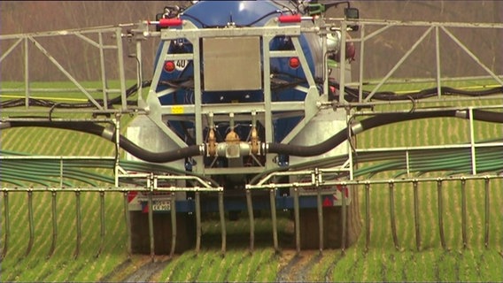 Eine landwirtschaftliche Maschine bringt Gülle auf ein Feld aus. © NDR 