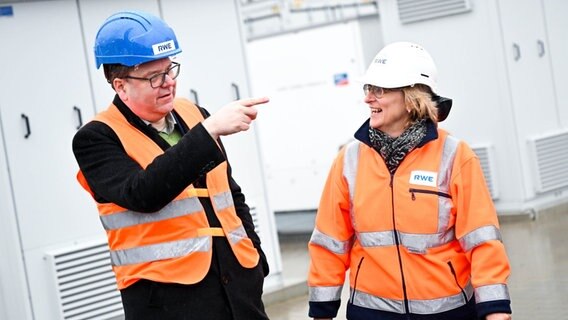 Niedersachsens Umweltminister Christian Meyer und Ute Brimberg, die Standortleiterin Gaskraftwerk Lingen, stehen vor der Megabatterie des Energiekonzerns RWE. © Sina Schuldt/dpa +++ dpa-Bildfunk Foto: Sina Schuldt