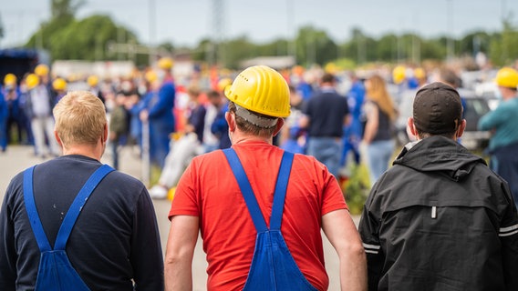 Mitarbeiter der Meyer Werft nehmen an einer Betriebsversammlung im Freien teil. © dpa-Bildfunk Foto: Mohssen Assanimoghaddam