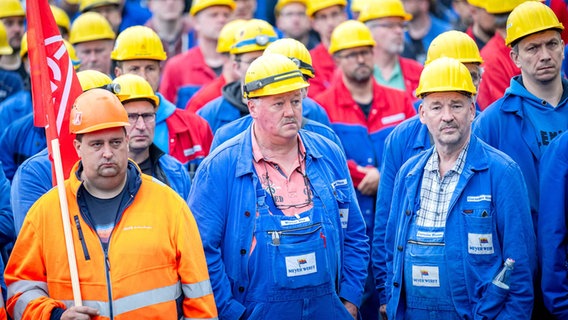 Mitarbeitende der Meyer Werft stehen für eine Kundgebung vor dem Werkstor. © dpa-Bildfunk Foto:  Sina Schuldt/dpa