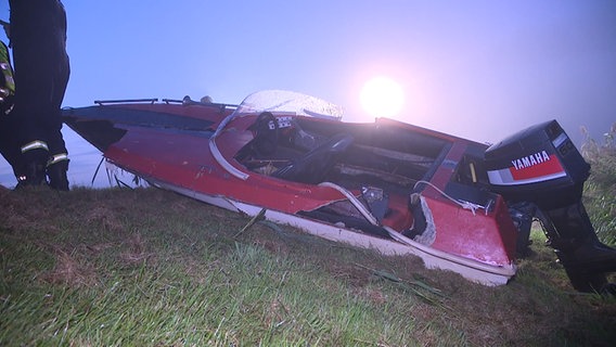 Ein beschädigtes Motorboot liegt am Flussufer. © NonstopNews 