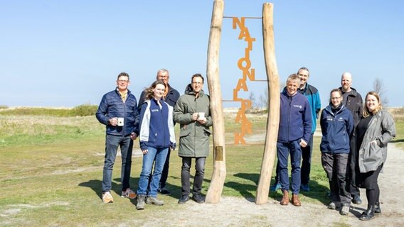 Folgende Personen stehen neben "Eingangs-Stelen" mit dem Wort "Nationalpark" in Schillig: Peter Podein (stv. Bürgermeister Gemeinde Wangerland), Karla Schulze (Nationalparkverwaltung), Ingo Krause, Armin Kanning (beide Wangerland Touristik), Peter Südbeck (Nationalparkverwaltung), Markus Haarmann (Artec), Sandra Berheide (Nationalparkverwaltung), Manfred Ahten (Artec), Anja Goldenstein (Wangerland Touristik). © Wiebke Kreinick / NLPV Foto: Wiebke Kreinick / NLPV