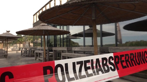Absperrband der Polizei vor Sonnenschirmen des Beachclubs in Nethen (an einem See im Ammerland). Hier hat es einen Brand gegeben. © NonstopNews 