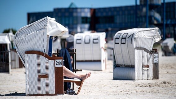 Norddeich: Ein Mensch sitzt in einem Strandkorb am Strand von Norddeich. © dpa-Bildfunk Foto: Sina Schuldt/dpa