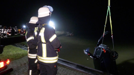 Feuerwehrleute hieven ein Auto aus einem Schleusenbecken in Norden. © NonstopNews 