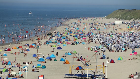 Zahlreiche Menschen halten sich am Strand von Norderney auf. © dpa-Bildfunk Foto: Volker Bartels