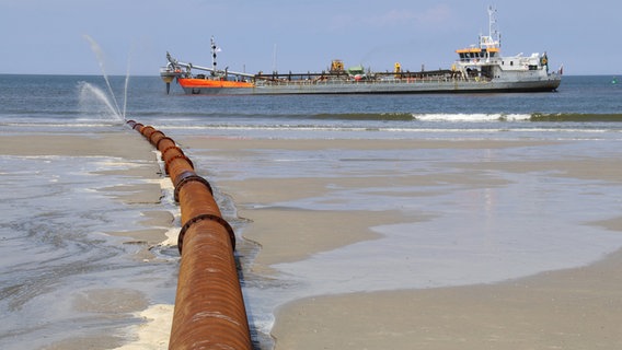 Norderney: Ein Schiff ist vor der Küste zu sehen, an der abgetragene Sanddepots vor Schutzdünen wiederaufgespült und Dünenketten verstärkt werden. © Volker Bartels/dpa | dpa-Bildfunk Foto: Volker Bartels