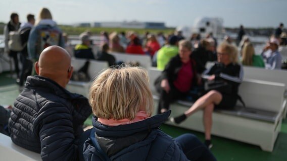 Fahrgäste sitzen an Deck der Fähre nach Norderney. © picture alliance/dpa Foto: Lars Penning (Klemmer)