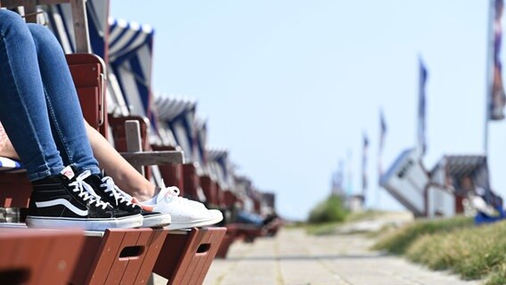 Norderney: Tagesgäste haben es sich im Strandkorb bequem gemacht und genießen das Sonnenwetter. © picture alliance Foto: Lars Penning (Klemmer)