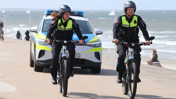 Eine Polizistin und ein Polizist fahren auf Elektrofahrrädern auf der Insel Norderney. © picture alliance/dpa/Volker Bartels Foto: Volker Bartels