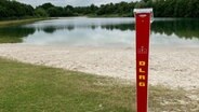 Eine Notrufsäule der DLRG steht an einem Badestrand. © NDR Foto: Frank Jakobs