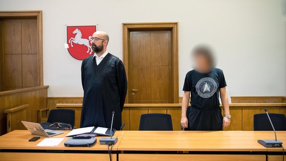 Ein Angeklagter (rechts) steht vor Prozessbeginn mit seinem Anwalt Tobias Pohl im Gerichtssaal. © dpa Foto: Sina Schuldt